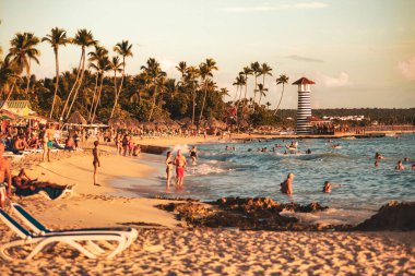 Dominik Cumhuriyeti, Dominik Cumhuriyeti 20 Ağustos 2025: Dominik Cumhuriyeti 'nin Bayahibe plajında günbatımında ikonik deniz fenerinin yanında yüzen turistler