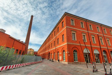 Modena, İtalya 20 Ağustos 2025: yeniden canlandırılmış kırmızı tuğla mimarisi ve simgesel baca modena, İtalya 'daki tarihi manifattura tabacchi' yi vurguluyor.