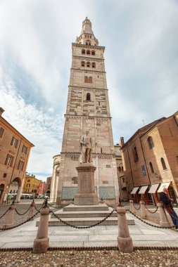 Modena, İtalya 20 Ağustos 2025: İtalya 'nın Modena şehrindeki Ciro Menotti heykelinin heykeliyle görkemli bir şekilde Piazza Grande üzerinde yükselen ghirlandina Kulesi