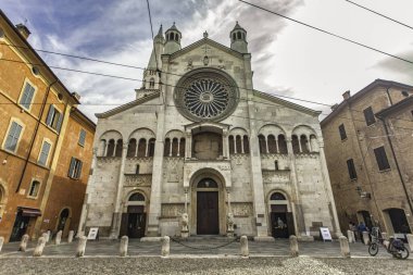 Modena, İtalya 20 Ağustos 2025: Modena Katedrali 'nin karmaşık cephesi göz kamaştırıcı bir gül penceresi, iki çan kulesi ve Roma tarzı detaylı oymalar içerir.