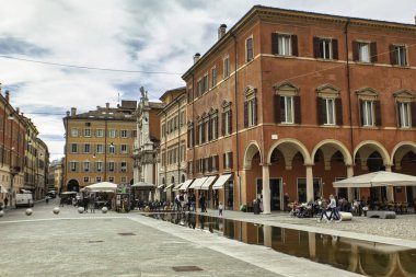 Modena, İtalya 'da 20 Ağustos 2025: Modena, İtalya' da Piazza Roma 'dan hoşlanan insanlar, su üzerinde geziniyorlar ve renkli binalara hayran kalıyorlar.