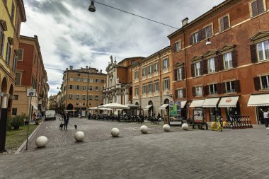 Modena, İtalya 20 Ağustos 2025: Modena, İtalya 'nın tarihi şehir merkezinde açık kafesi ve kilisesi olan parke taşı meydanı.