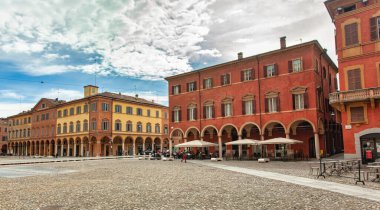 Modena, İtalya 20 Ağustos 2025: turistler güneşli bir günde Piazza xx settembre, modena, İtalya 'da renkli tarihi binalarla çevrili bir kafede eğleniyorlar.