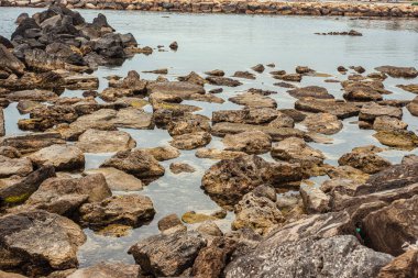 Civitavecchia, İtalya 20 Ağustos 2025: Sakin kayalık kıyı şeridi kısmen sivitavecchia, İtalya 'nın sakin sularına batmış ve sakin bir deniz manzarası oluşturmuştur.