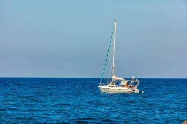 Cala sa figu, İtalya 20 Ağustos 2025: Cala figu, sardunya, İtalya 'da sakin mavi sularda yüzen yeşil yelkenli.