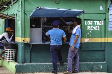 Cueva de chico, Dominik Cumhuriyeti 20 Ağustos 2025: İşçiler Cueva de chico, Dominik Cumhuriyeti 'nde renkli bir büfede mola verip su içiyorlar.
