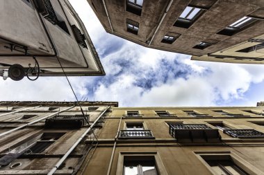 Cagliari, İtalya 19 Ağustos 2025: Balkonlu ve pencereli konut binaları alçak bir açıdan görülüyor, İtalya, Cagliari 'de bulutlu bir gökyüzü ortaya çıkıyor.