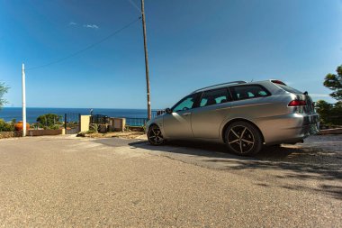 Costa rei, İtalya 20 Ağustos 2025: Bir alfa Romeo 156 spor araba yol kenarına park edilmiş güneşli bir yaz gününde güzel bir deniz manzarasının keyfini çıkarır.