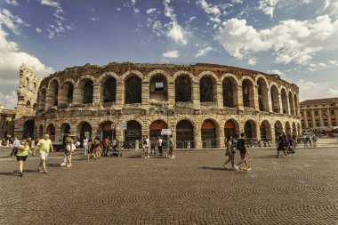 Verona, İtalya, 20 Ağustos 2025: Güneşli bir yaz gününde Verona Arena yakınlarında yürüyen turistler, Piazza Sutyen, Verona, İtalya 'da bir Roma amfitiyatrosu.