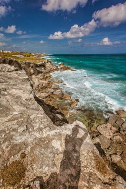 Isla Mujeres, Meksika 20 Ağustos 2025: fotoğrafçının gölgesi, büyüleyici turkuaz Karayip denizinin Isla Mujeres 'in kayalık kıyılarına çarpması.