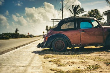 Isla Mujeres, Meksika 20 Ağustos 2025 üstü açık eski kırmızı Volkswagen böceği Isla Mujeres, Meksika 'da yol kenarına park etmiş güneşli tropikal titreşimlerin tadını çıkarıyordu.