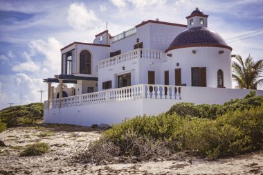 Isla mujeres, Meksika 20 Ağustos 2025: Beyaz lüks villa kumlu sahilde yuva yapmış, Ila Mujeres 'de geleneksel Meksika mimari tasarımı var.