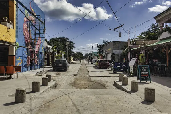 Tulum, Meksika 20 Ağustos 2025: Tulum Pueblo, Meksika sokak manzarası, güneşli bir günde arabaları, binaları, duvar resimlerini, elektrik hatlarını ve sokak tamiratlarını gösteriyor