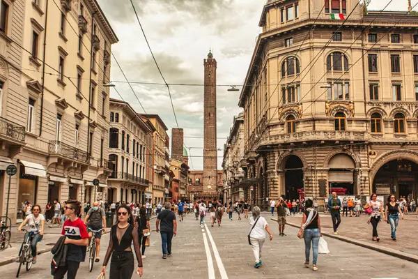 Bolonya, İtalya 19 Ağustos 2025: Bologna 'da popüler bir sokak olan Rizzoli üzerinden yürüyen insanlar, arka planda asinelli kulesi var.