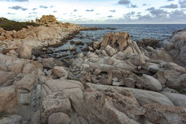 Muhteşem granit kaya oluşumları günbatımında turkuaz bir deniz tarafından Punta molentis, sardunya, İtalya 'da yıkanmıştır.