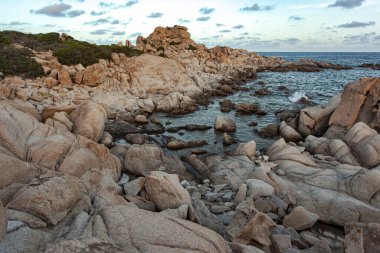 Granit kayalar Akdeniz 'le Punta Molentis, Sardunya' da buluşur ve günbatımında dramatik bir kıyı manzarası yaratır.