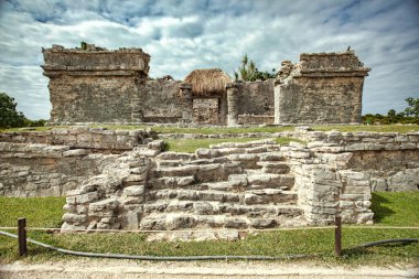 Antik Maya harabeleri bulutlu bir gökyüzüne karşı dimdik durarak Tulum, Meksika 'daki Maya medeniyetinin zengin tarihi ve mimari hünerlerini sergiliyor.