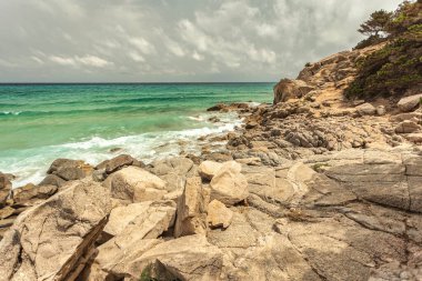 Turkuaz dalgalar yavaşça Monte Turnu, İtalya 'nın kayalık kıyılarına vurarak sakin bir kıyı manzarası yaratıyor.