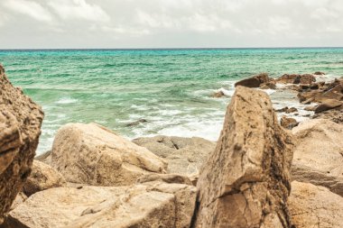 Turkuaz deniz suyu bulutların altında kayalık kıyılara çarpıyor. Monte Turnu, İtalya 'da sakin bir atmosfer yaratıyor.