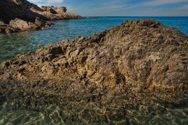 Güneş ışığı, İtalya 'nın sardunya kentindeki Cala sa figüsünün kristal berrak suyundan çıkan deniz tabanını aydınlatır ve nefes kesici bir deniz manzarası yaratır.
