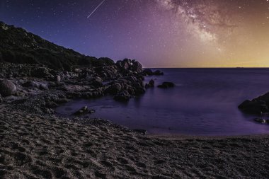 İtalya, Sardunya 'daki Capo Ferrato Sahili gece kayan yıldızlarla aydınlatılıyor.