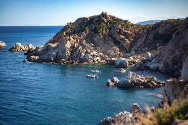 Güneşli bir yaz gününde İtalya 'nın Sardunya kentindeki Capo Ferrato sahilini gezen turistleri taşıyan iki sandal.