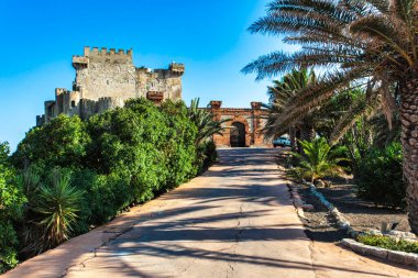 Güneşli bir günde İtalya, Sicilya 'da Falconara' da Akdeniz manzaralı bir tepede görkemli bir şekilde duran Şahin Şatosu.