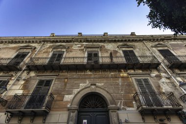 Tarihsel bir binanın çökmüş cephesi demir balkonları ve Falconara 'da çürüyen alçıyla zamanın nasıl geçtiğini gösteriyor.