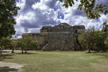 Majestic Maya rasathanesi el caracol bulutlu gökyüzüne karşı dimdik duruyor, Meksika, Chichen itza 'da yemyeşil alanda antik mimariyi sergiliyor.