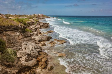 Turkuaz dalgalar, Karayip Denizi, Meksika 'da tropikal bir ada olan Isla Mujeres' in kayalık sahillerine çarpıyor ve güzel bir kıyı manzarası yaratıyor.