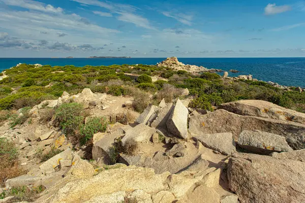 Engebeli sahil şeridi ve punta molentis turkuaz sularının nefes kesici manzarası, İtalya, Sardunya 'da çarpıcı bir plaj.