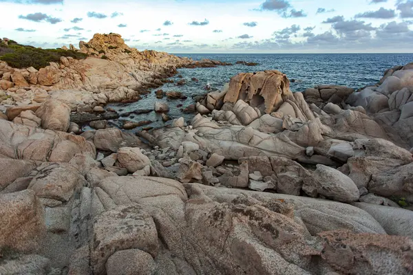 Muhteşem granit kaya oluşumları günbatımında turkuaz bir deniz tarafından Punta molentis, sardunya, İtalya 'da yıkanmıştır.