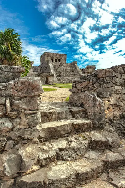 Meksika 'daki antik Maya kalıntılarına doğru uzanan taş basamaklar dramatik, bulutlu bir gökyüzü tarafından çerçevelenmiş.