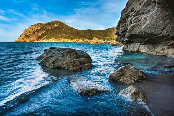 Cala sa figu 'da kayaların üzerinde süzülen dalgaların manzarası, sardunya, İtalya' da kristal berraklığında turkuaz su ve çarpıcı bir zemin.