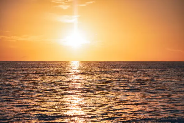 Batan güneş Dominicus 'un sakin okyanus suları boyunca ılık bir altın parıltı yayar, sakin ve nefes kesici bir sahne yaratır.