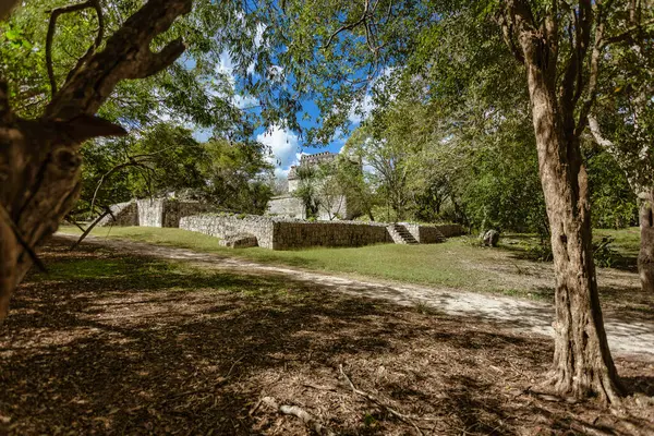 Güneş ışığı ağaçların arasından süzülüyor, Meksika 'daki bir unesco dünya mirası alanı olan Chichen itza' daki antik Maya kalıntılarını aydınlatıyor.