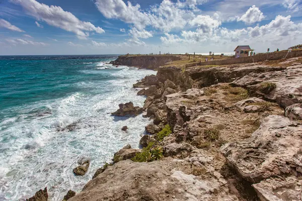 Turkuaz okyanus dalgaları güneşli bir günde Isla Mujeres, Meksika 'da kayalık bir kıyı şeridine çarparak muhteşem bir deniz manzarası yaratıyor.