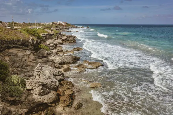Turkuaz dalgalar, Karayip Denizi, Meksika 'da tropikal bir ada olan Isla Mujeres' in kayalık sahillerine çarpıyor ve güzel bir kıyı manzarası yaratıyor.