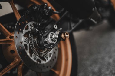 Padova, italy 1 october 2025: motorcycle rear wheel closeup featuring an orange alloy rim, disc brake, and mechanical components, highlighting detail and engineering