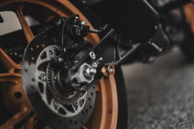 Padova, italy 1 october 2025: motorcycle rear wheel featuring an orange rim and detailed disc brake system, emphasizing precision engineering and speed