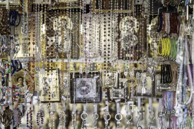 Padova, italy 1 october 2025: market stall in padua with colorful rosary bracelets, catholic icons and devotional souvenirs arranged in vibrant handmade displays