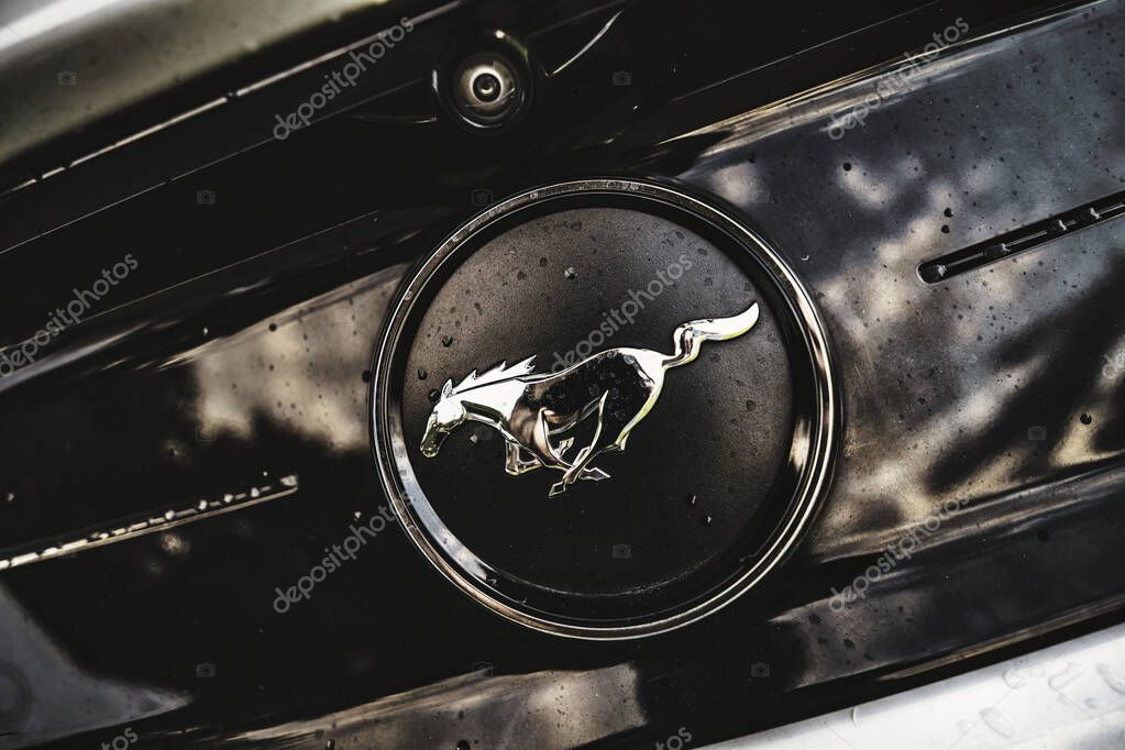Rome, italy 30 september 2025: ford mustang running horse emblem on wet chrome of a classic muscle car, evoking speed, power and vintage automotive style