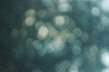  Soyut altın ve beyaz bokeh koyu arkaplanda daireler çizerek rüya gibi ve zarif bir bulanık efekt yaratır..