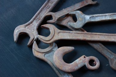 Eskimiş dokularını ve endüstriyel cazibelerini gözler önüne seren eskimiş, paslı anahtarlar ve karanlık bir yüzeyde bir kanca. Klasik alet meraklıları için mükemmel.