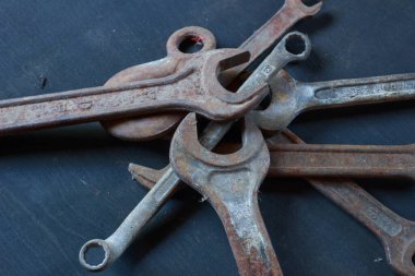 Eskimiş dokularını ve endüstriyel cazibelerini gözler önüne seren eskimiş, paslı anahtarlar ve karanlık bir yüzeyde bir kanca. Klasik alet meraklıları için mükemmel.