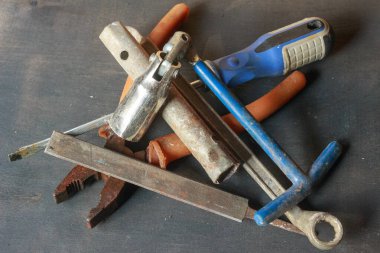 Eskimiş dokularını ve endüstriyel cazibelerini gözler önüne seren eskimiş, paslı anahtarlar ve karanlık bir yüzeyde bir kanca. Klasik alet meraklıları için mükemmel.