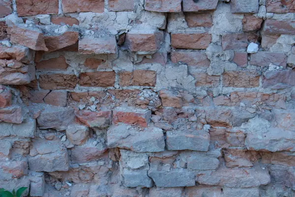 Eski, yıpranmış tuğla bir duvarın dokusu ve soyulmuş alçı kalıntıları. Sanatsal tasarım arka planı