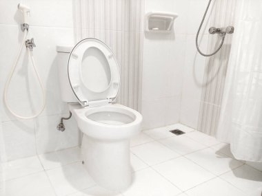 Parlak ışıklı bir tuvalette lekesiz beyaz bir tuvaleti gösteren fotoğraf, ferahlık ve hijyen yayar, ticari alanlarda, otellerde veya konutlarda modern tesisleri sergilemek için mükemmeldir.