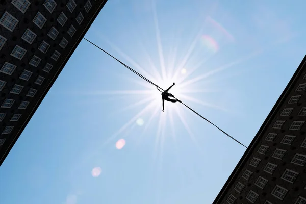 Silhouette of tightrope walker balancing on the rope concept of risk taking
