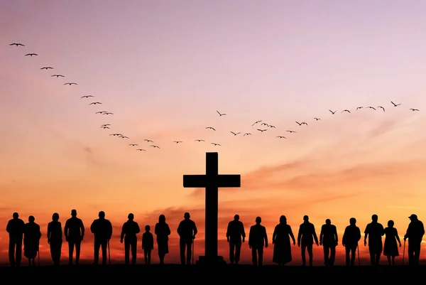 stock image Large group of people stand near cross against backdrop of sunset, resurrection of Easter Sunday concept